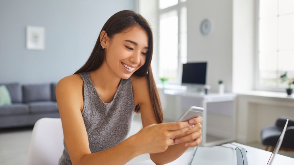 a woman smiling at her mobile game